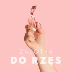 Dłoń trzyma różową zalotkę do rzęs. Czy zalotka niszczy rzęsy? Dowiedz się więcej o pielęgnacji.
