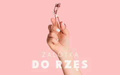 Dłoń trzyma różową zalotkę do rzęs. Czy zalotka niszczy rzęsy? Dowiedz się więcej o pielęgnacji.