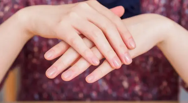 Delikatne dłonie z naturalnym blaskiem, efekt japońskiego manicure. Paznokcie zadbane i lśniące, podkreślające subtelność.