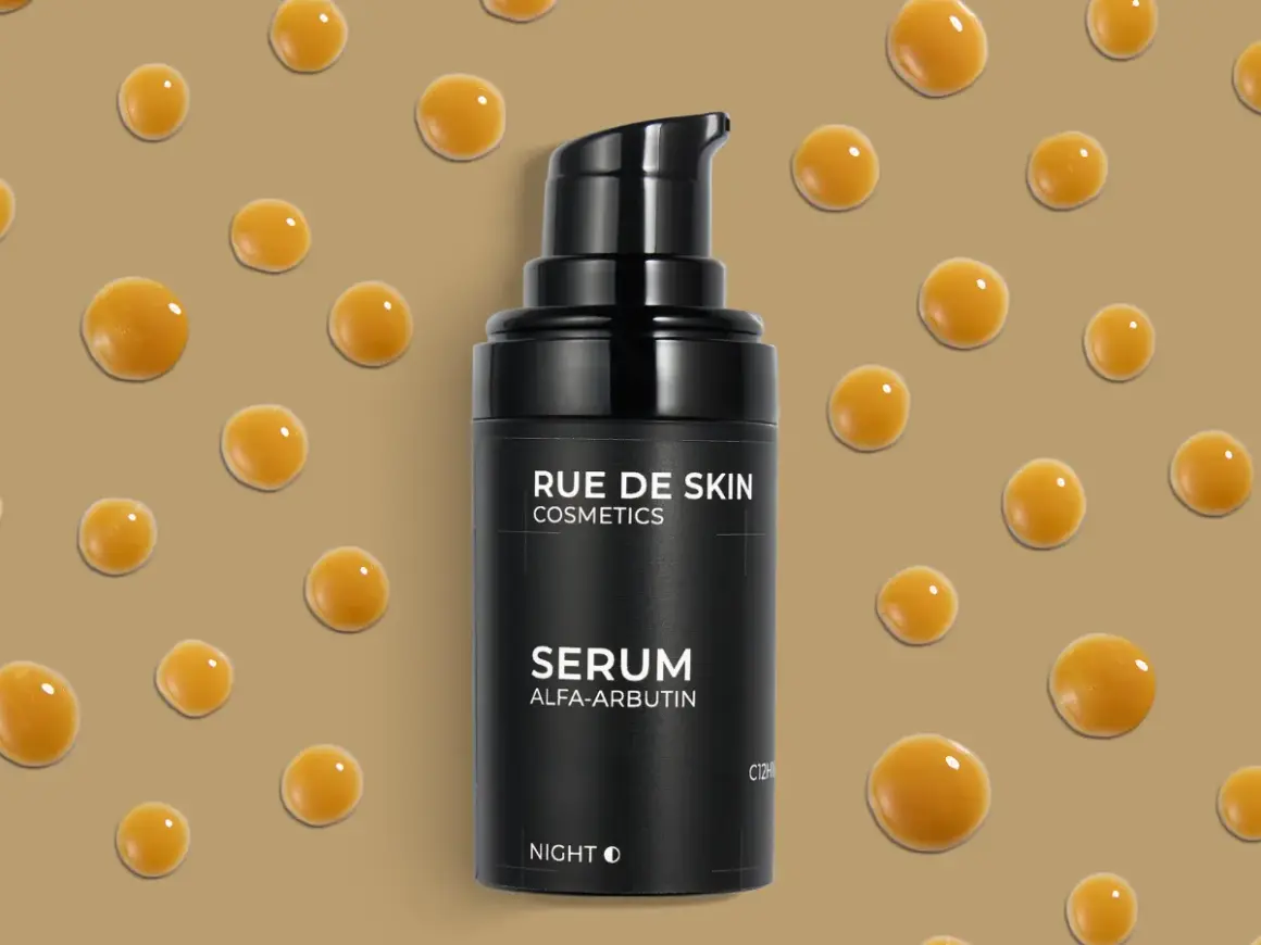 Czarny flakonik serum z alfa-arbutyną, otoczony kropelkami o bursztynowym odcieniu. Idealny do nocnej pielęgnacji.