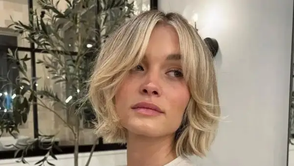 Kobieta z blond włosami w stylu cienkie włosy bob warstwowy cieniowany, z delikatnymi falami i grzywką na bok.
